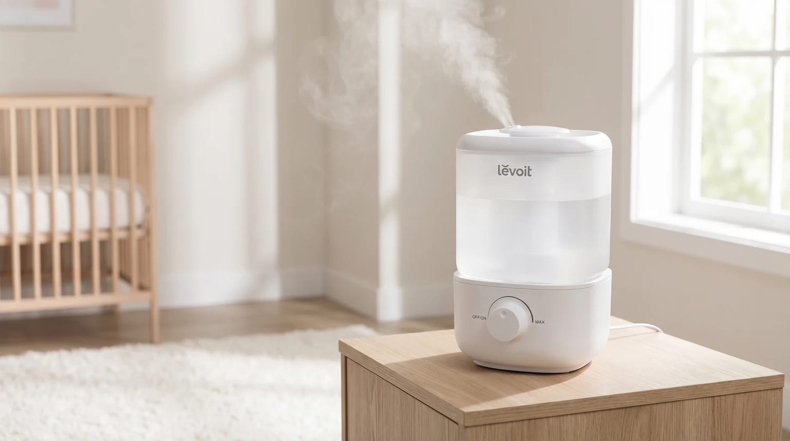 Humidificador branco da Levoit numa mesa de cabeceira de madeira num quarto de bebé claro e sereno. O aparelho está a emitir uma névoa suave.