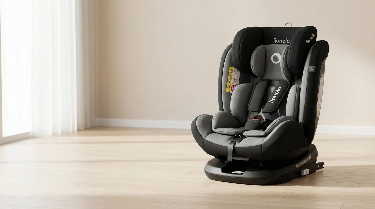 Cadeira auto Lionelo Bastiaan preta e cinzenta num ambiente interior claro com parede suave, chão claro e luz natural.