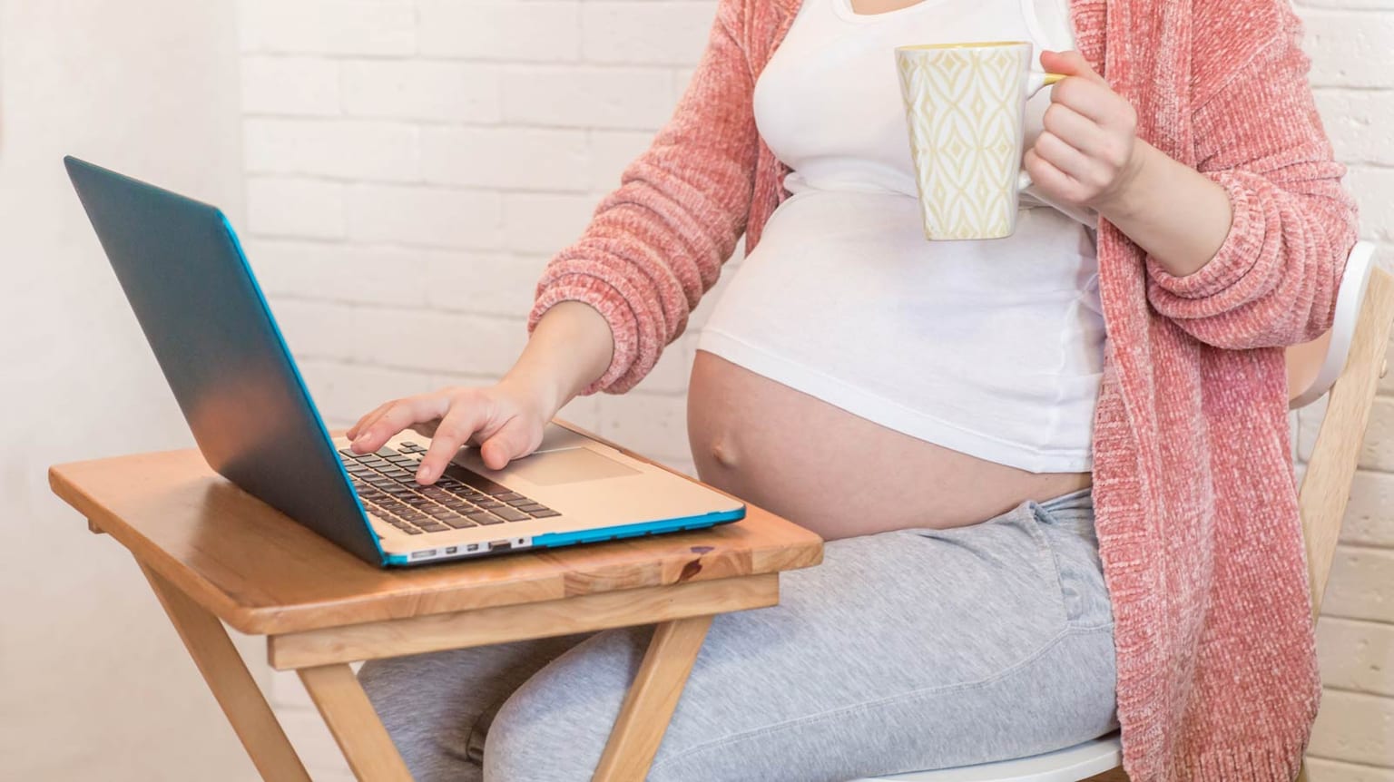 Mulher grávida a utilizar um computador portátil