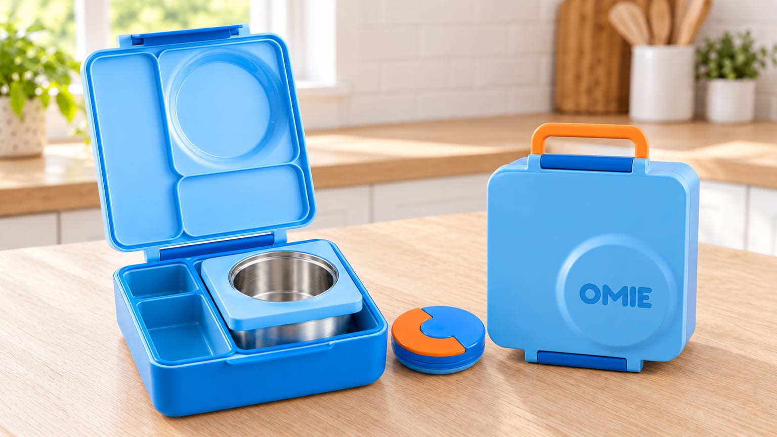 OmieBox infantil azul, aberta com recipiente em inox e fechada com pega laranja.