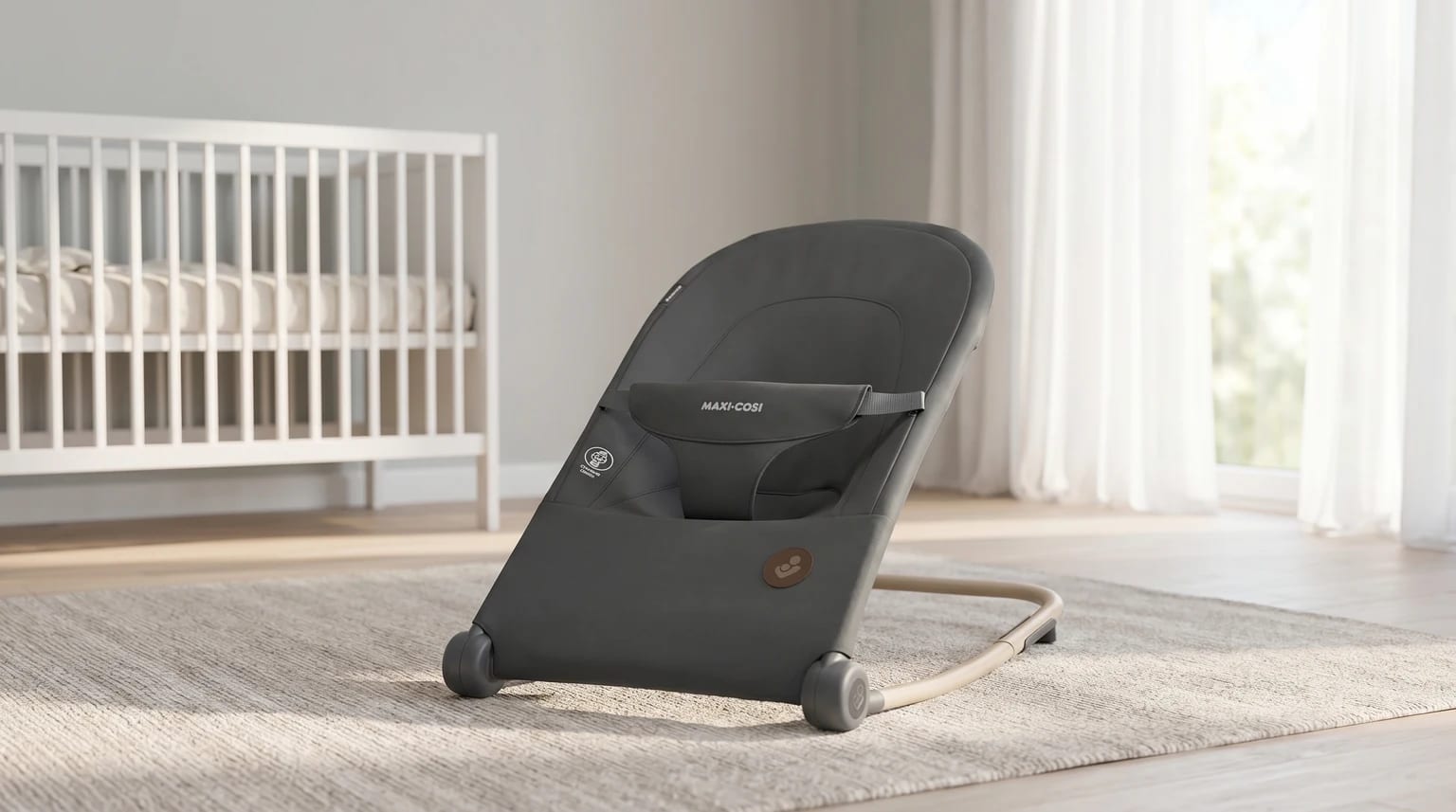 Espreguiçadeira Maxi-Cosi Loa cinzenta escura num quarto de bebé moderno e bem iluminado, junto a uma janela com luz natural.