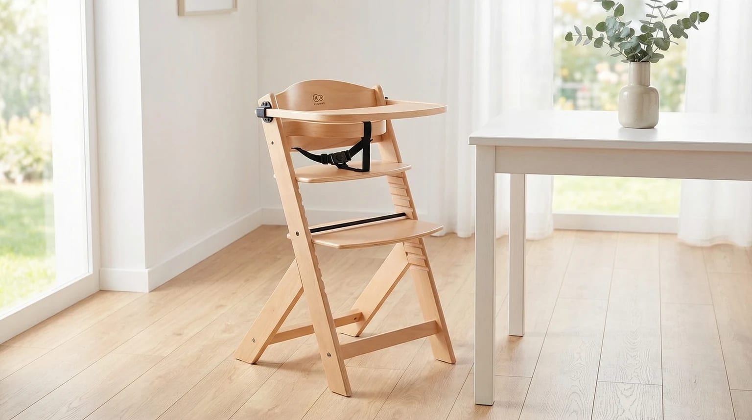 Cadeira de refeição evolutiva Kinderkraft ENOCK em madeira clara, posicionada numa sala de jantar moderna e luminosa ao lado de uma mesa.