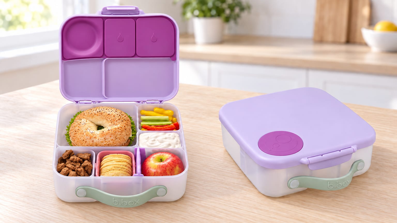 Lancheira infantil b.box lilás, aberta com os compartimentos visíveis e fechada com pega verde.